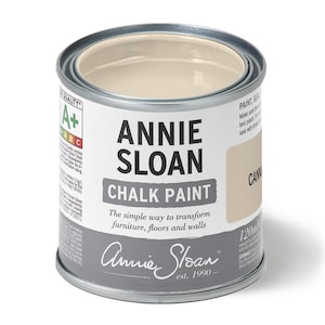Puede incluir: Una lata de pintura a la tiza Annie Sloan en el color "Canvas". La etiqueta muestra el nombre de la marca y los detalles del producto, con texto que indica que la pintura es para muebles, suelos y paredes. La lata contiene 120 ml de pintura.