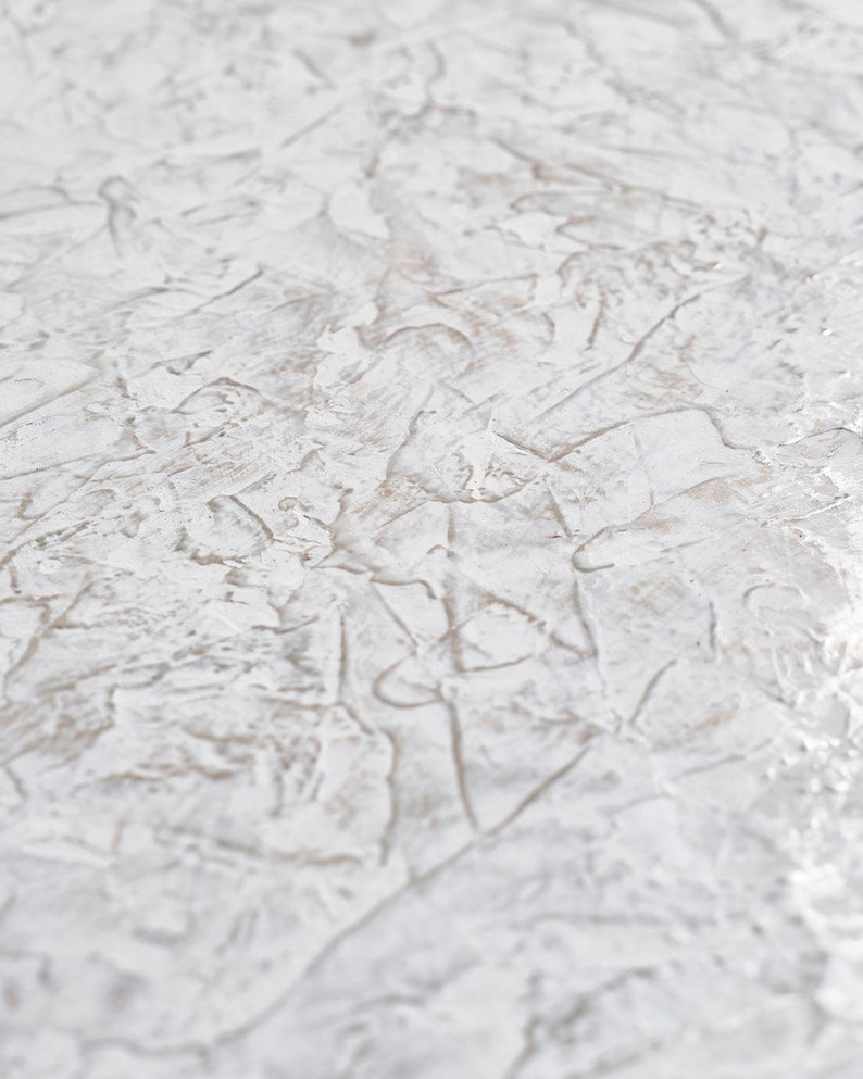 May include: White textured surface with a subtle pattern of raised lines and swirls. The surface has a slightly rough, uneven texture.