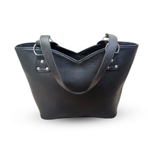 May include: A black leather tote bag with two top handles. The bag has a V-shaped opening and silver hardware.