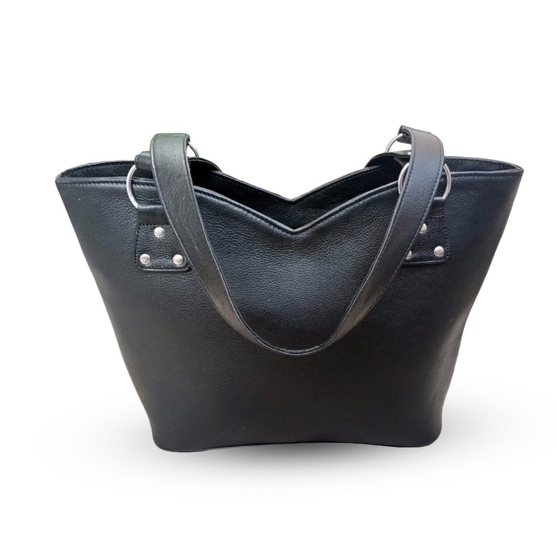 May include: A black leather tote bag with two top handles. The bag has a V-shaped opening and silver hardware.