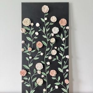 12 x 24 inch wall art on canvas with a charcoal gray background and 3D textured ivory and blush roses and green stems and leaves. The roses are piped and adhered with acrylic modeling paste.