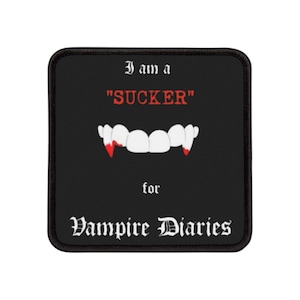 May include: Black and white patch with the text "I am a "SUCKER" for Vampire Diaries" in a gothic font. The patch features a set of vampire fangs with red dripping blood.