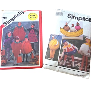 May include: Two Simplicity sewing pattern envelopes for children's food-themed costumes. The left envelope features fruit and vegetable designs like grapes, strawberries, and pumpkins. The right envelope displays banana, egg, and other food-shaped outfits.