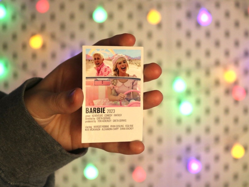 Pu&ograve; includere: Un poster di film rosa e bianco per il film "Barbie", uscito nel 2023. Il poster presenta una foto di Margot Robbie e Ryan Gosling in una macchina convertibile rosa. Il testo sul poster recita "Avventura Commedia Fantasy", "Greta Gerwig", "Tom Ackerley", "Greta Gerwig", "Margot Robbie", "Ryan Gosling", "Issa Rae", "Kate McKinnon", "Alexandra Shipp" e "Emma Mackey".
