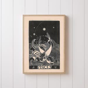 May include: Framed black and white art print featuring two fish swimming in stylized waves under a starry sky. The word "PISCES" is at the bottom. The artwork is in a light-colored wooden frame.