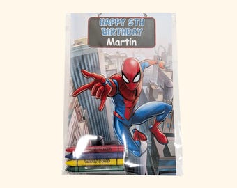 May include: A rectangular clear plastic package containing a coloring activity sheet featuring a red and blue superhero character in a city setting. The text reads HAPPY 5TH BIRTHDAY Martin. Four wax crayons in red, blue, yellow, and green are included.