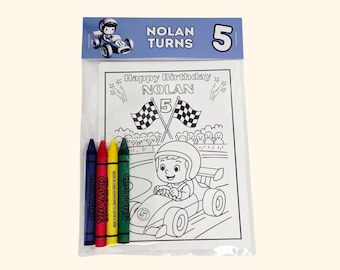 May include: A clear plastic bag containing a coloring activity set with four crayons in blue, red, yellow, and green. The header card reads NOLAN TURNS 5. The coloring page features a race car driver, checkered flags, and the text Happy Birthday NOLAN 5.