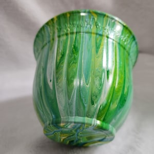 May include: A green, white, and yellow painted ceramic planter with a wavy, marbled design.