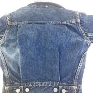 May include: A blue denim jacket with a classic design. The jacket has a button-up front, long sleeves, and two pockets on the front.
