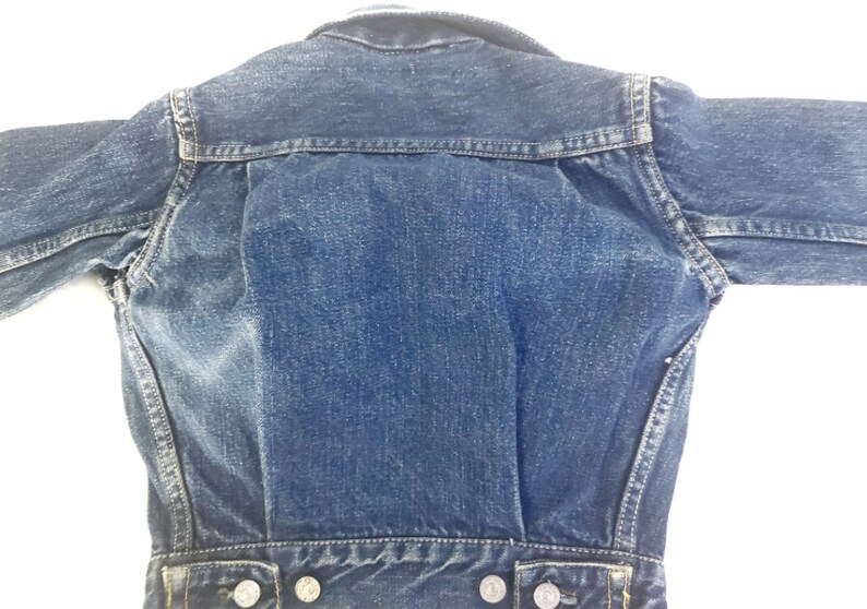 May include: A blue denim jacket with a classic design. The jacket has a button-up front, long sleeves, and two pockets on the front.
