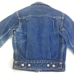 May include: A blue denim jacket with a button closure and long sleeves. The jacket has a faded look and is in good condition.