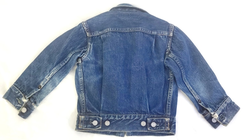 May include: A blue denim jacket with a button closure and long sleeves. The jacket has a faded look and is in good condition.