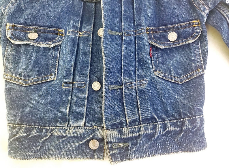 May include: A blue denim jacket with a button fastening, two chest pockets, and two front pockets. The jacket has a worn look and is made of a soft, comfortable fabric.