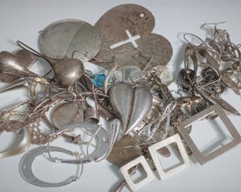 Puede incluir: Una colección de joyas plateadas, que incluye pendientes, colgantes y cadenas. El surtido presenta varias formas, como corazones, cuadrados y diseños abstractos. Algunas piezas tienen un acabado texturizado, otras son lisas.