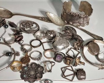 Puede incluir: Una colección de joyas de plata, que incluye anillos, pulseras, collares y pendientes. Las joyas están dispuestas sobre una superficie blanca e incluyen una variedad de estilos y diseños.