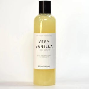 May include: A clear bottle of Very Vanilla Body Serum with a black cap. The label reads "Very Vanilla Body Serum" with "With Shea Butter and Beeswax" below. The bottle contains 8 fl oz / 235ml of serum.