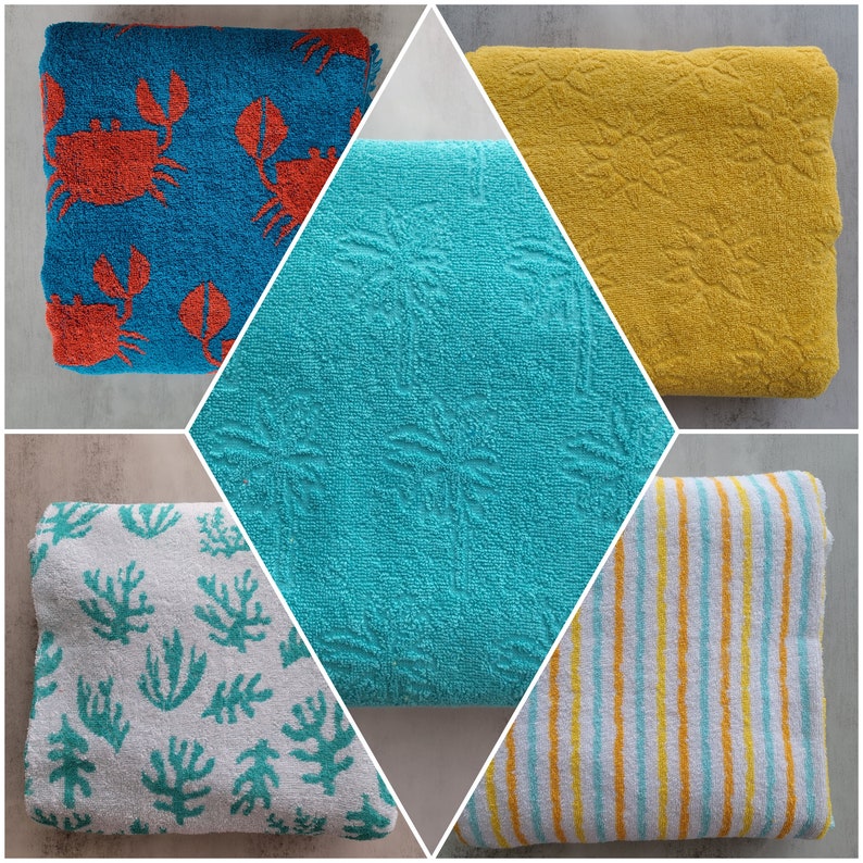Op de afbeelding: Vier verschillende strandhanddoeken met verschillende patronen. E&eacute;n handdoek is blauw met een wit patroon en rode krabben, een andere is geel met een wit patroon, een andere is wit met een blauw-geel gestreept patroon en de laatste is wit met een groen bladerpatroon.
