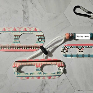 May include: Three colorful patterned keychains with a white cord and a black clip. The keychain has two holes and the text "Name here" on a white tag.