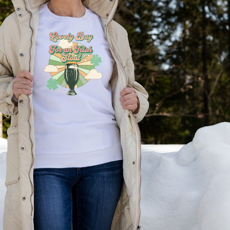 May include: White sweatshirt with a retro-style graphic of a glass of beer and the text "Lovely Day for an Irish Stout".