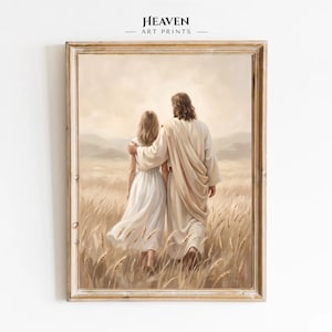 May include: A framed art print titled Heaven Art Prints featuring a figure with long hair in a white robe with an arm around a person in a white dress, both walking through a golden wheat field under a soft, hazy sky in a light wood frame.