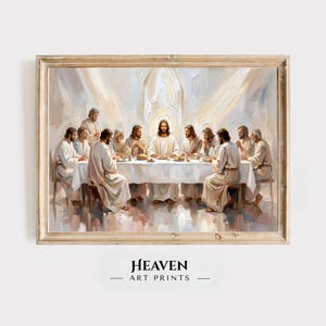 Op de afbeelding: Een ingelijste olieverfschilderij-print die het Laatste Avondmaal toont, met Jezus in het midden van een lange tafel omringd door twaalf figuren in gewaden. De scène bevat zachte, lichte penseelstreken en een warme, etherische gloed. Onder de lijst staat de tekst HEAVEN ART PRINTS.