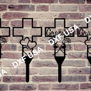 Op de afbeelding: Vier zwarte metalen tuinstokken met kruisen en harten. De kruisen hebben de woorden "Oma" en "Opa" erop. De stokken zijn ontworpen om in de grond te worden geplaatst.