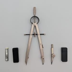 May include: A set of silver drafting tools, including a large compass, a small compass, and two black cases. The compasses have sharp points and adjustable arms. The set also includes a silver lead holder.
