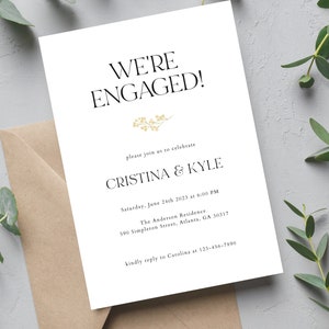 Puede incluir: Una tarjeta de anuncio de boda blanca con letras doradas. La tarjeta dice "We're Engaged!" e incluye los nombres "Cristina & Kyle" y la fecha "Saturday, June 24th 2023 at 6:00 PM".