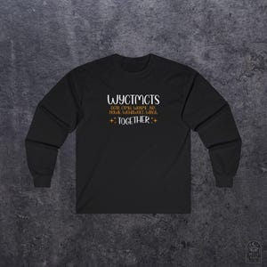 May include: Black long-sleeve shirt with white text: "WYCTMCTS" above "TOGETHER" and other text. The shirt has a crew neck and long sleeves. The text is in a handwritten style font.