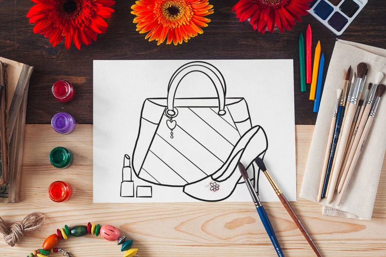 Puede incluir: Dibujo lineal en blanco y negro de un bolso, un zapato de tac&oacute;n y un l&aacute;piz labial sobre una hoja de papel blanca. El dibujo est&aacute; rodeado de materiales de arte, incluyendo pinceles, crayones y pintura. Flores rojas y naranjas en el fondo.