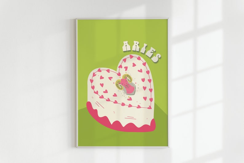 May include: A green background with a white heart-shaped cake decorated with pink hearts. The cake has a pink ram in the center with gold horns. The text "ARIES" is in a retro font at the top of the image.