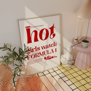 May include: A white framed poster with red text that reads "hot girls watch formula 1". The poster is hanging on a white wall with a light brown wooden floor.
