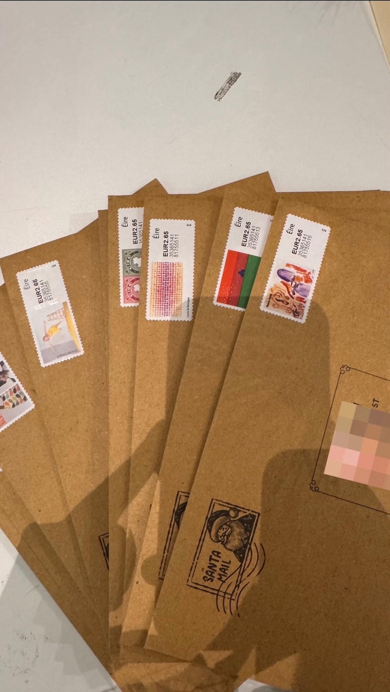 May include: Several brown paper envelopes with postage stamps attached. The stamps display diverse designs and colours. Some envelopes are stamped with "SANTA MAIL". The stamps are marked "Eire" and "EUR2.65".