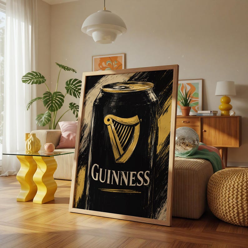 May include: A framed art print featuring a black and gold Guinness can design. The artwork showcases the iconic harp logo and the word "Guinness" in white lettering. The background has a textured, brushstroke effect.