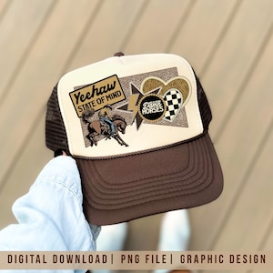 Puede incluir: Gorra de camionero marrón y blanca con visera marrón y parte trasera de malla. El panel frontal presenta un vaquero montando a caballo, las palabras "Yeehaw State of Mind" y otros elementos gráficos. La gorra tiene una visera curva.