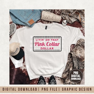 Può includere: Felpa bianca con la scritta "LIVIN' ON THAT Pink Collar DOLLAR" in un design rosa e nero. L'immagine include un berretto da baseball, jeans, stivali e pantaloni mimetici. Sono visibili anche le parole "PNG DIGITAL DOWNLOAD".