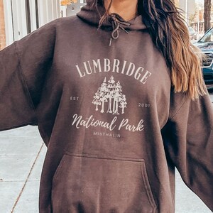 May include: A brown hoodie with a white graphic print that says "Lumbridge National Park Est. 2001 Michigan".