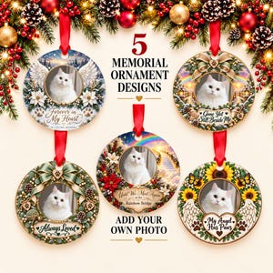 May include: Five round memorial ornaments featuring a white cat in the center of each. Designs include wreaths, angel wings, sunflowers, and rainbows with text such as Forever in My Heart, Gone Yet Still Beside Me, Always Loved, and My Angel Has Paws.