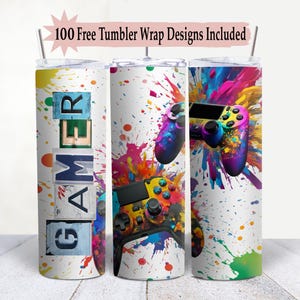 May include: Three stainless steel tumblers with colorful paint splatter designs. One tumbler features the word "GAMER" in colorful letters. The other two tumblers feature a colorful video game controller design.