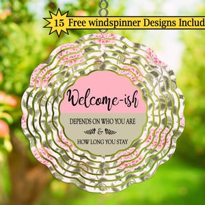 May include: A decorative, layered metal wind spinner with a floral design and the text "Welcome-ish." The text continues, "Depends on who you are & how long you stay." The spinner includes 15 free windspinner designs.