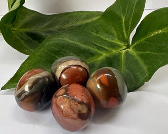 May include: Four smooth, polished, red, brown, and gray jasper stones. The stones are round and have a natural, organic look.