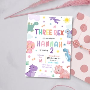 May include: A colourful invitation for a birthday party with a dinosaur theme. The invitation says "Three Rex" and "Hannah is turning 2". The invitation features a pink, blue, and green dinosaur.