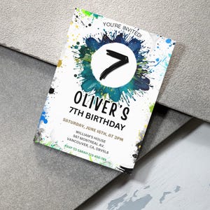 Puede incluir: Una tarjeta de invitaci&oacute;n blanca con salpicaduras de pintura coloridas y el texto "YOU'RE INVITED!" y "OLIVER'S 7TH BIRTHDAY". La tarjeta presenta un gran n&uacute;mero 7 dentro de un dise&ntilde;o de salpicaduras azul y verde. Incluye detalles del evento.
