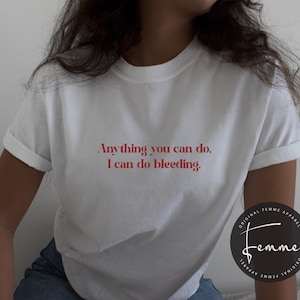 May include: White t-shirt with red text that reads "Anything you can do, I can do bleeding."