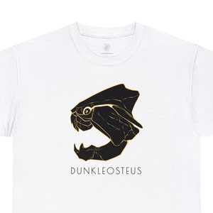May include: White t-shirt featuring a black and gold illustration of a Dunkleosteus, an extinct armoured fish, with the text "Dunkleosteus" beneath the illustration.