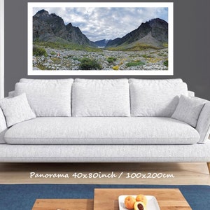 May include: A panoramic photograph of a mountain range with a valley in the foreground. The mountains are rocky and covered in vegetation. The sky is cloudy and the valley is filled with rocks and vegetation. The image is printed on canvas and framed. The text "Panorama 40x80inch / 100x200cm" is printed below the image.