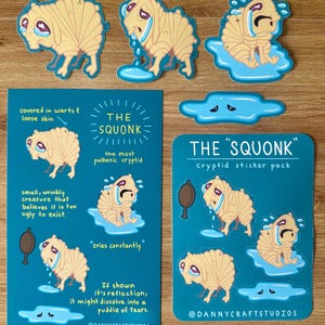 May include: A collection of stickers and prints featuring the cryptid known as the Squonk. The Squonk is depicted as a beige, wrinkly creature with a sad expression, often crying. The stickers are 3 inches in size, and the prints are 5x8 inches.