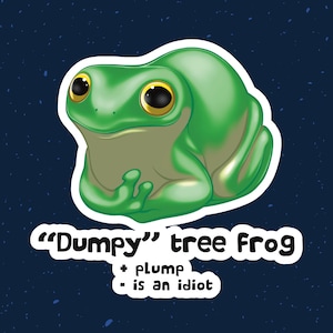 May include: A green cartoon sticker of a plump tree frog with large yellow-rimmed eyes. The sticker has the text "Dumpy tree Frog" and the phrases "+ plump" and "- is an idiot" in white text on a dark blue background.
