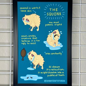May include: A framed print featuring a cartoon illustration of "The Squonk," a mythical creature. The artwork depicts the Squonk with a sad expression, crying tears. Text on the print describes the Squonk's characteristics and mentions it dissolves into tears if it sees its reflection.
