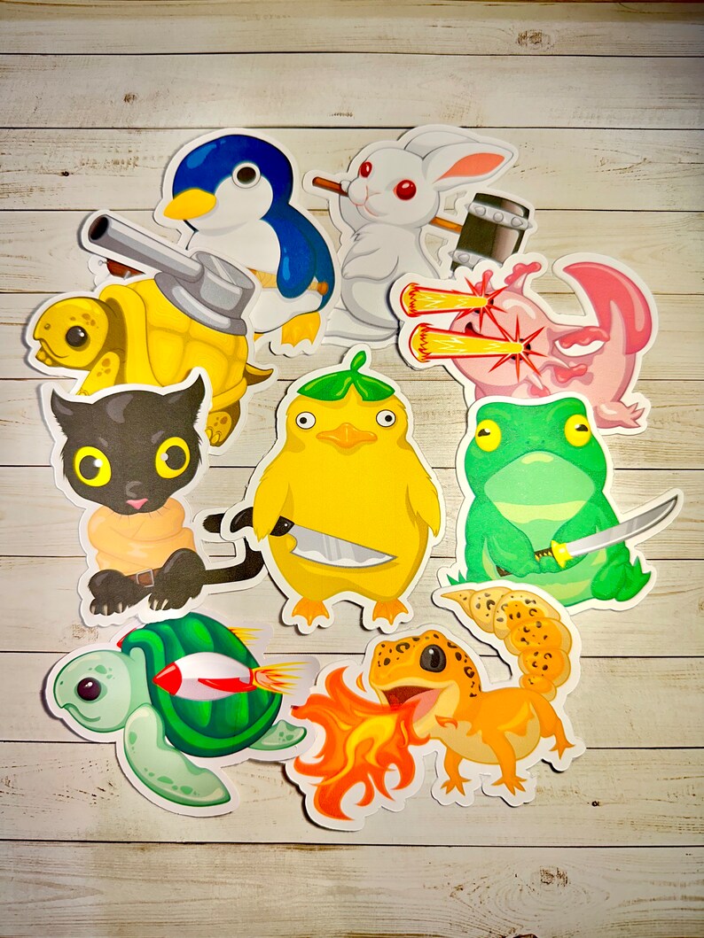 Peut inclure: Un ensemble de neuf autocollants color&eacute;s repr&eacute;sentant diff&eacute;rents animaux avec des armes et des accessoires uniques. Les autocollants comprennent une tortue avec un canon, un pingouin avec un couteau, un lapin avec un marteau, un axolotl avec des yeux laser, un chat avec une &eacute;p&eacute;e, un canard avec un couteau, une grenouille avec un katana, un gecko avec du feu et une tortue avec une fus&eacute;e.